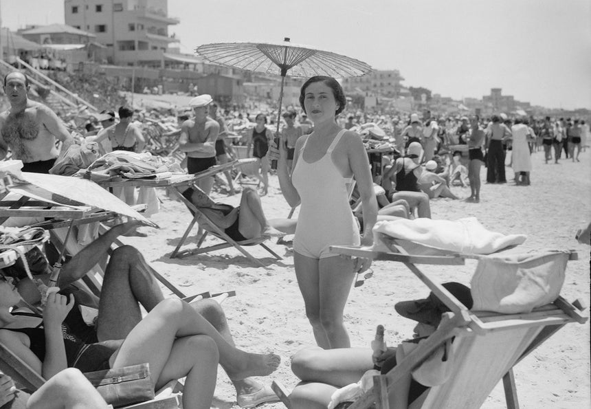 A woman with a parasol on the beach